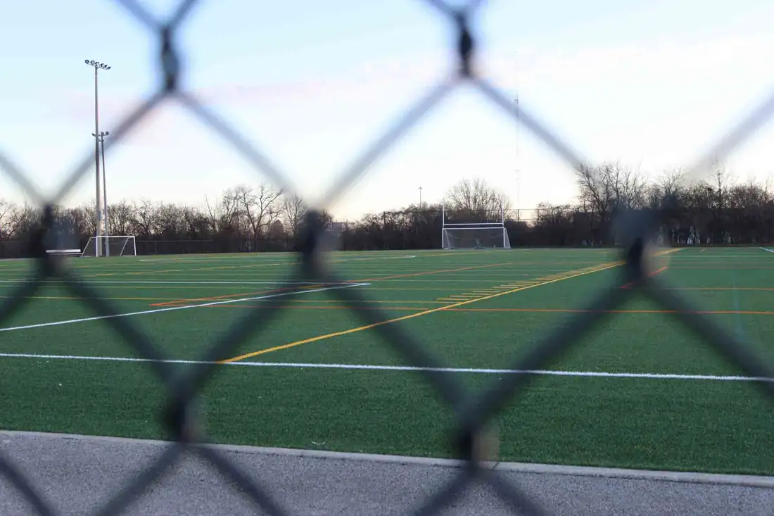 Tall chain link fence around an athletic field