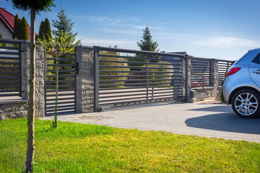 Automatic sliding driveway gate across a paved entrance