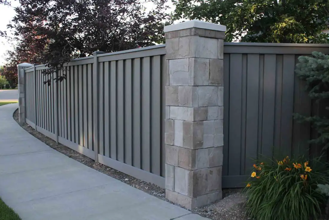 Gray composite fence with stone pillar