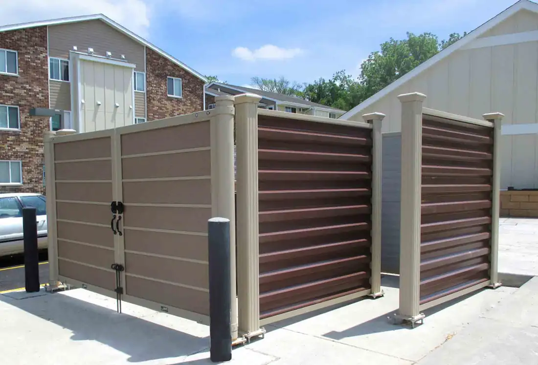 Horizontal board dumpster enclosure beside a commercial building