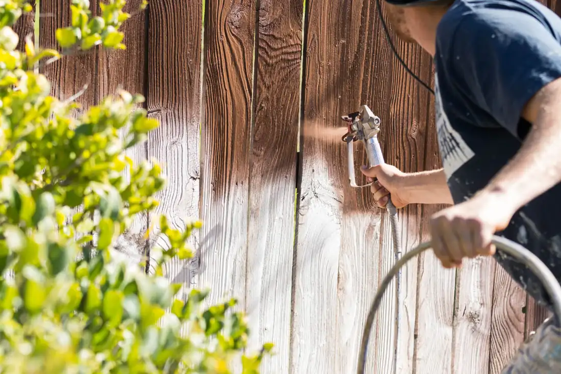 Installer setting wood fence posts in a backyard