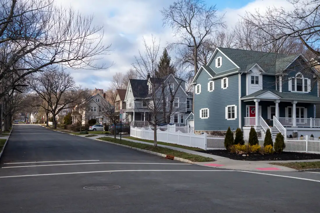 Row of homes with picket fences along a neighborhood street